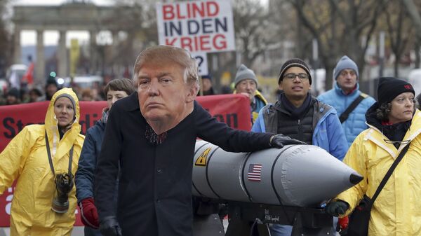 Um manifestante anti-guerra usa uma máscara mostrando o presidente dos EUA, Donald Trump, em Berlim, Alemanha, durante uma manifestação contra as armas nucleares perto do Portão de Brandemburgo, em 18 de novembro de 2017 - Sputnik Brasil