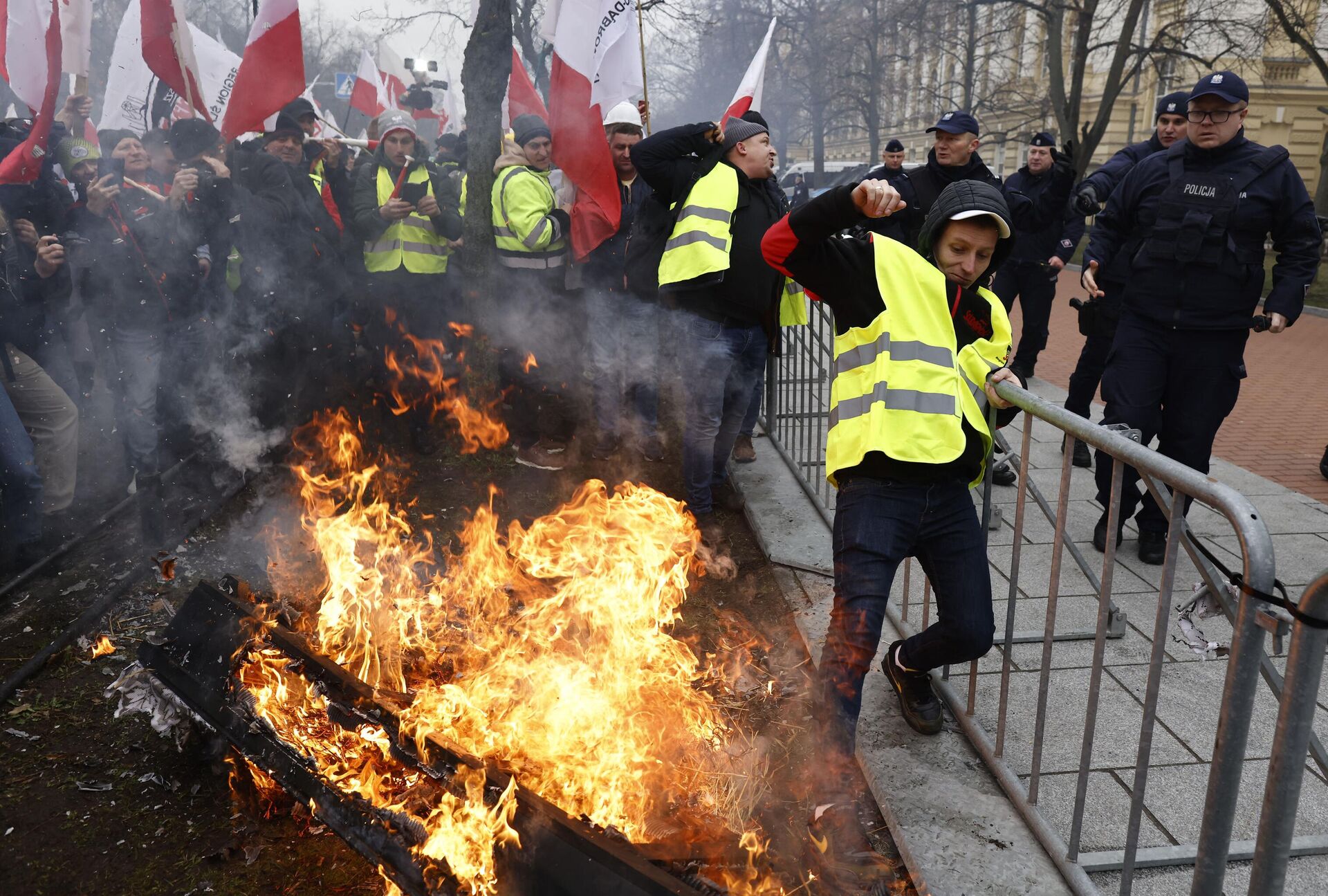 Agricultores poloneses manifestam-se com fogo e bandeiras contra as medidas climáticas da UE e as importações ucranianas em 6 de março de 2024 em frente ao edifício do Parlamento em Varsóvia, Polônia - Sputnik Brasil, 1920, 06.03.2024
