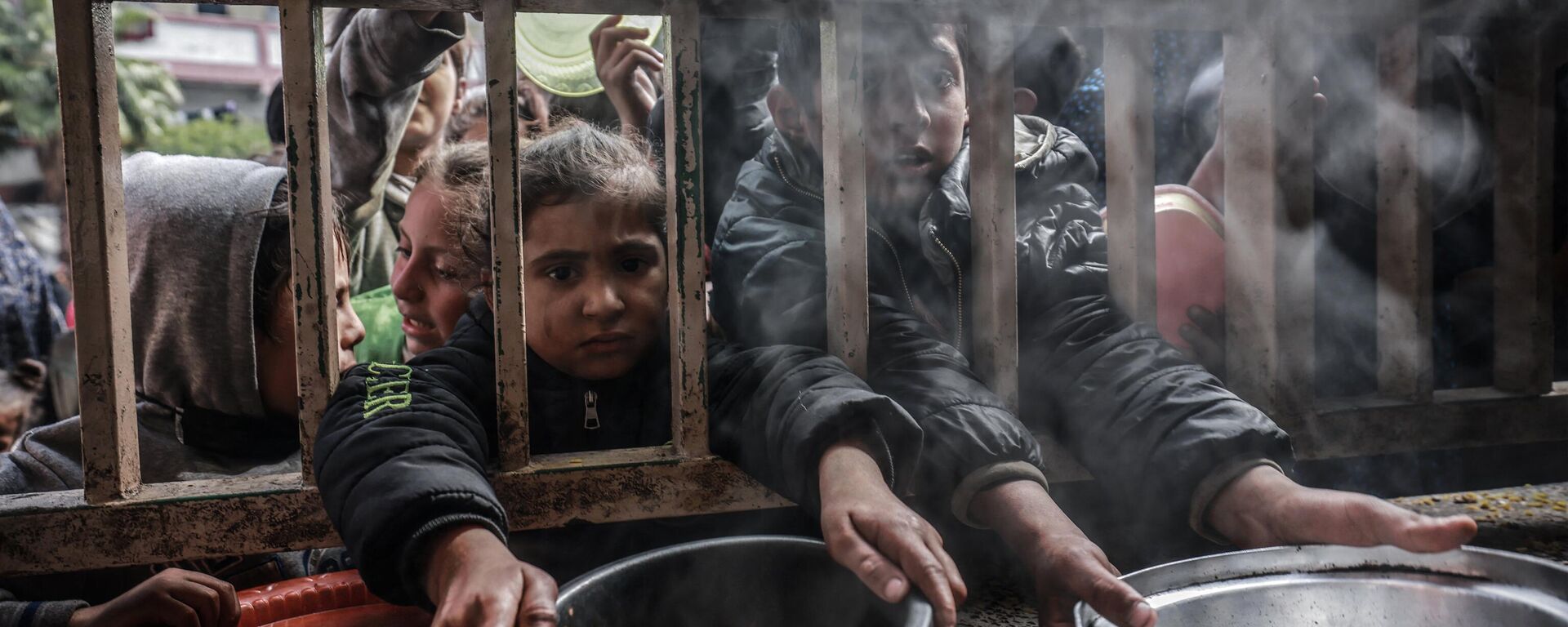 Crianças palestinas deslocadas se reúnem para receber comida em uma escola pública em Rafah, no sul da Faixa de Gaza, em 19 de fevereiro de 2024 - Sputnik Brasil, 1920, 20.03.2024