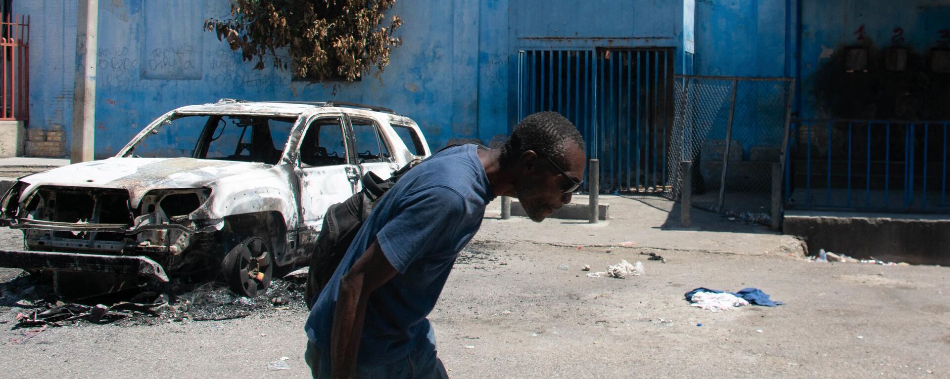 Um homem sai da área da prisão e abaixa a cabeça por causa do tiroteio nas proximidades, em Porto Príncipe, Haiti, 4 de março de 2024 - Sputnik Brasil, 1920, 12.03.2024