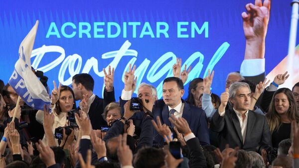 Luís Montenegro, líder da Aliança Democrática, de centro-direita (ao centro), e sua esposa, Carla (à esquerda), gesticulam para apoiadores após declararem vitória nas eleições, em Lisboa. Portugal, 11 de março de 2024 - Sputnik Brasil