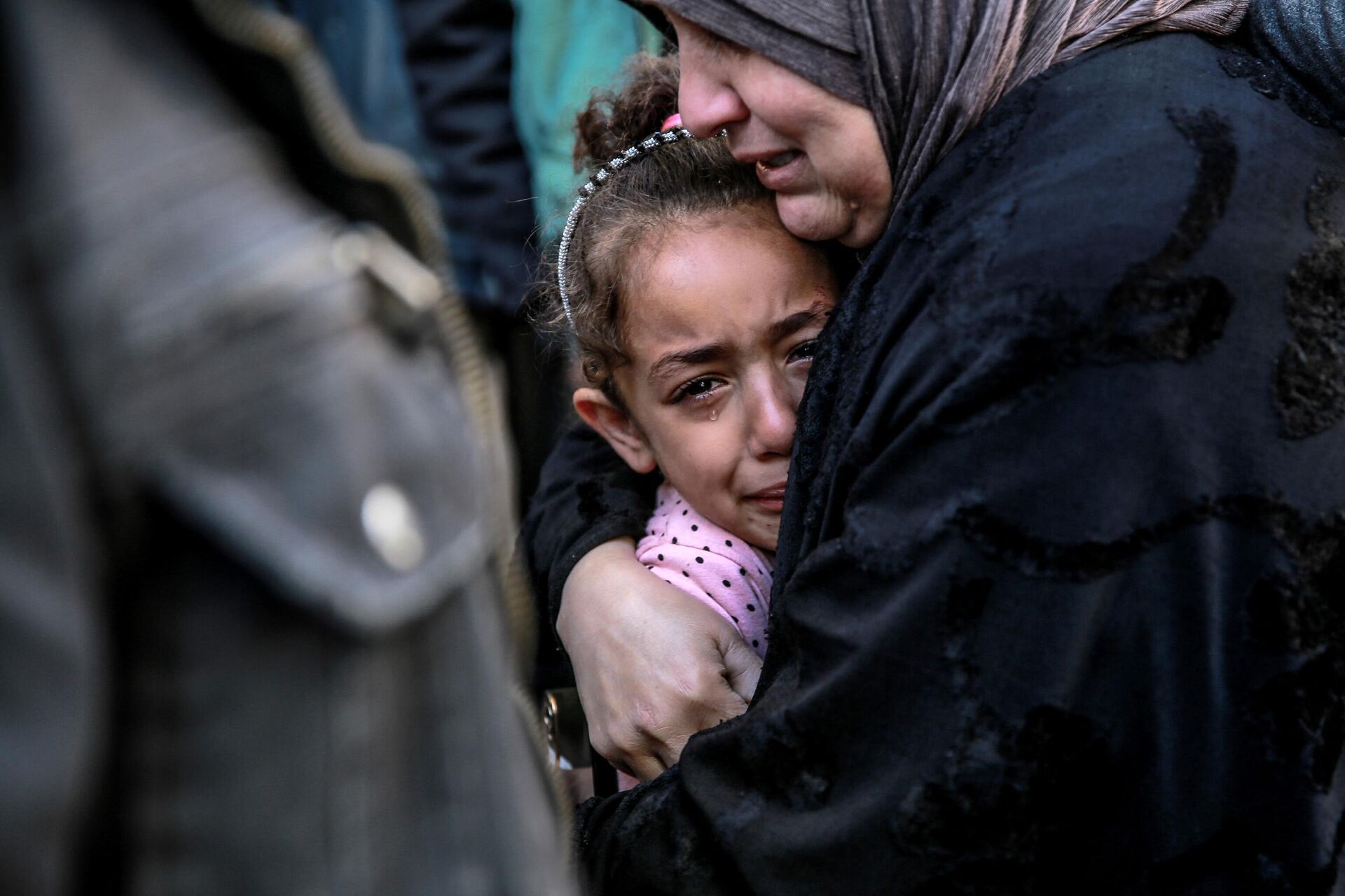 Mulher palestina abraça criança enquanto choram pelos parentes mortos no bombardeio israelense em frente ao necrotério do hospital Al-Shifa, na cidade de Gaza, em 15 de março de 2024 - Sputnik Brasil, 1920, 15.03.2024