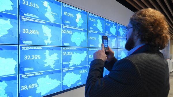 Um homem tira fotos de um video wall para monitorar o processo de votação nas eleições presidenciais russas de 2024 no Centro de Informações da Comissão Eleitoral Central (CEC), em Moscou, Rússia, 16 de março de 2024 - Sputnik Brasil