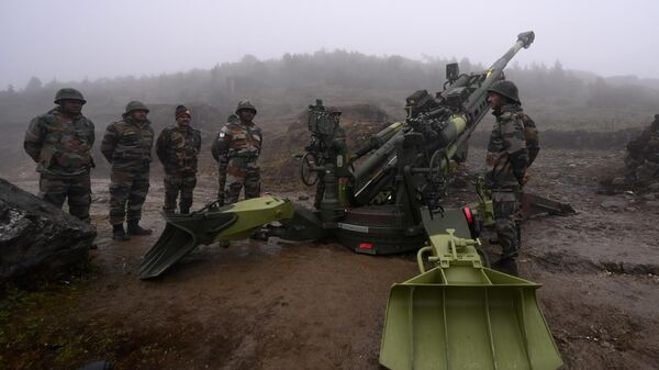 Soldados do Exército Indiano estão ao lado de um obus M777 ultraleve posicionado em Penga Teng Tso à frente de Tawang, perto da Linha de Controle Real (LAC), vizinha da China, no estado indiano de Arunachal Pradesh, em 20 de outubro de 2021 - Sputnik Brasil