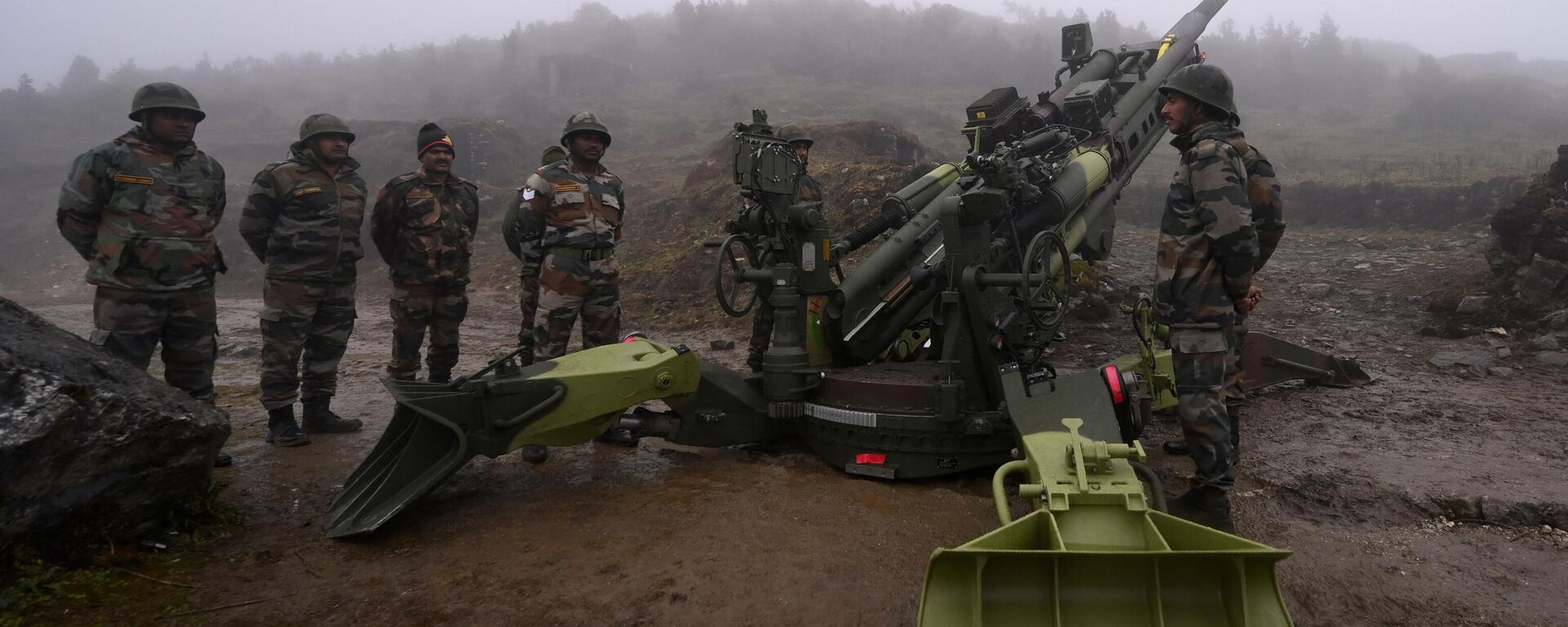 Soldados do Exército Indiano estão ao lado de um obus M777 ultraleve posicionado em Penga Teng Tso à frente de Tawang, perto da Linha de Controle Real (LAC), vizinha da China, no estado indiano de Arunachal Pradesh, em 20 de outubro de 2021 - Sputnik Brasil, 1920, 19.03.2024
