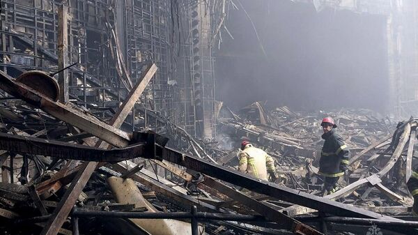 Bombeiros trabalham na sala de concertos do Crocus, queimada após o ataque ao prédio. Rússia, 23 de março de 2024 - Sputnik Brasil