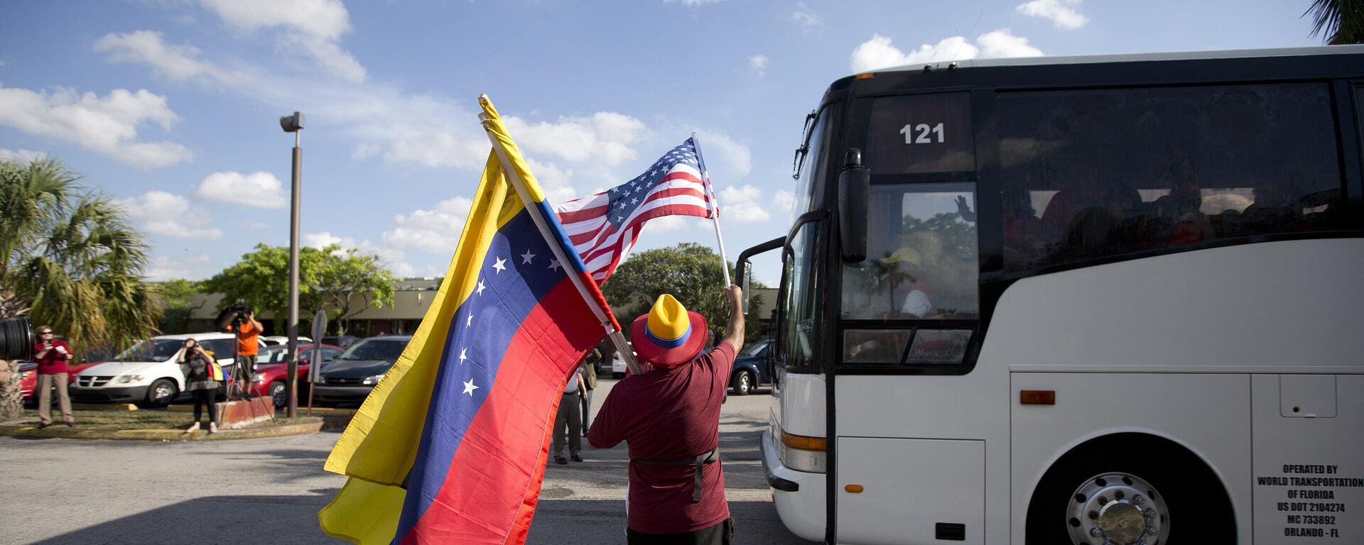 Homem agita bandeiras da Venezuela e dos Estados Unidos - Sputnik Brasil, 1920, 26.03.2024