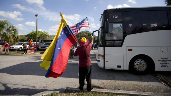Homem agita bandeiras da Venezuela e dos Estados Unidos - Sputnik Brasil