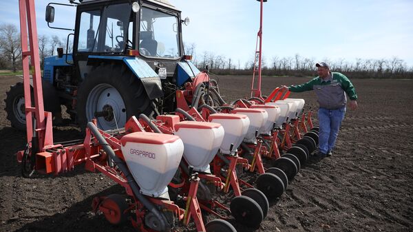 Um trabalhador prepara um veículo agrícola para semear sementes de girassol nos campos da empresa agrícola Progress Argo, na região de Krasnodar, na Rússia - Sputnik Brasil