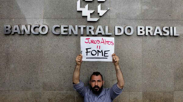 Manifestante segura placa que diz Juros altos = fome em frente ao Banco Central. Brasília, 21 de março de 2023 - Sputnik Brasil