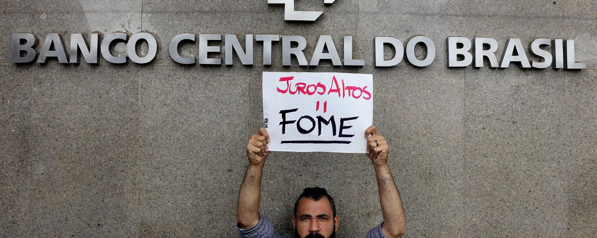 Manifestante segura placa que diz Juros altos = fome em frente ao Banco Central. Brasília, 21 de março de 2023 - Sputnik Brasil, 1920, 01.04.2024