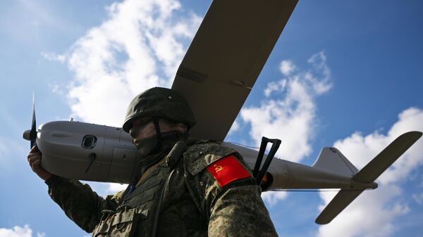 Um militar russo do grupo de forças Centro carrega um veículo aéreo não tripulado de reconhecimento Orlan-30 depois que ele voou no setor Avdeevka da linha de frente em meio à operação militar russa na Ucrânia, Rússia, 29 de março de 2024 - Sputnik Brasil