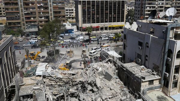 Equipes de resgate fazem buscas nos escombros de um prédio anexo à embaixada iraniana, um dia após um ataque aéreo em Damasco, em 2 de abril de 2024 - Sputnik Brasil
