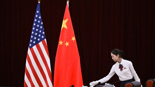 Um assistente fica ao lado das bandeiras da China e dos EUA antes de uma reunião entre a secretária do Tesouro dos EUA, Janet Yellen, e o vice-primeiro-ministro da China, He Lifeng, na Guangdong Zhudao Guest House, na cidade de Guangzhou, no sul da China, em 5 de abril de 2024 - Sputnik Brasil