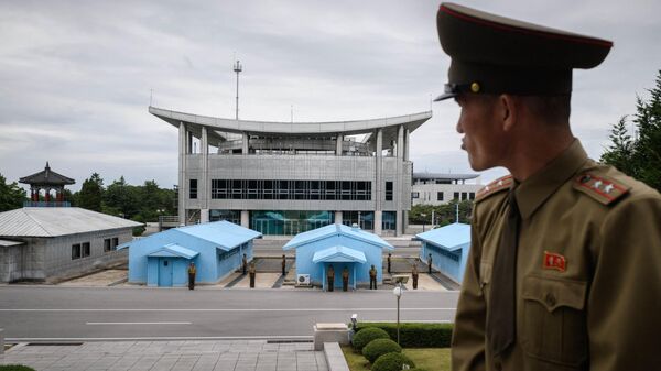 Soldado do Exército Popular Coreano, tenente-coronel Hwang Myong Jin, está diante do lado sul-coreano da vila de Panmunjom, no lado norte-coreano da Zona Desmilitarizada (DMZ) que separa a Coreia do Norte e do Sul, perto de Kaesong, (foto de arquivo) - Sputnik Brasil