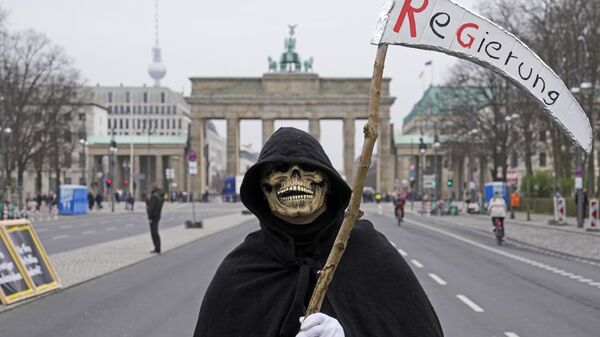 Manifestante vestido de morte em frente ao Portão de Brandemburgo, em Berlim, na Alemanha, segura foice com a palavra Governo durante um ato público de agricultores, em 22 de março de 2024 - Sputnik Brasil