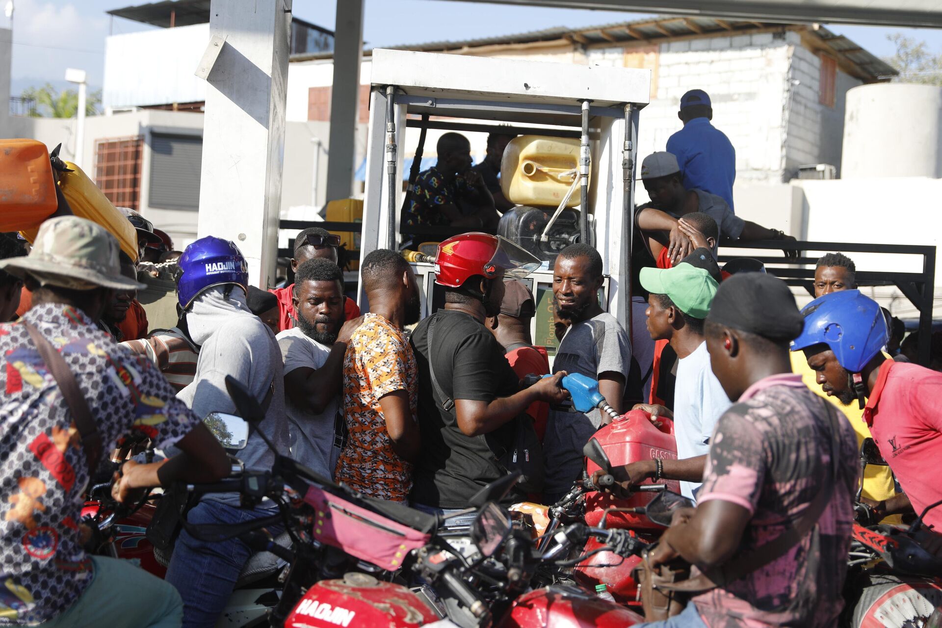 Pessoas se aglomeram em torno de uma bomba de combustível em posto de gasolina de Porto Príncipe. Haiti, 6 de abril de 2024 - Sputnik Brasil, 1920, 12.04.2024