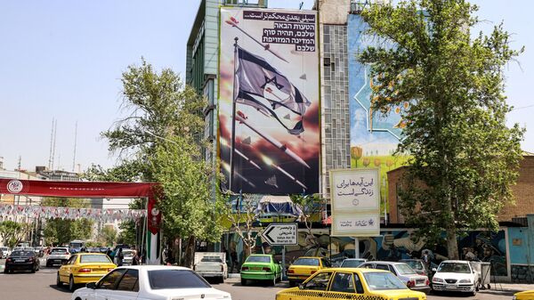 Veículos passam ao lado de prédio que retrata um cartaz com mísseis e drones voando ao lado de uma bandeira israelense rasgada, com um texto em persa que diz o próximo tapa será mais forte e em hebraico seu próximo erro será o fim do seu Estado falso, em Teerã, Irã, 14 de abril de 2024 - Sputnik Brasil