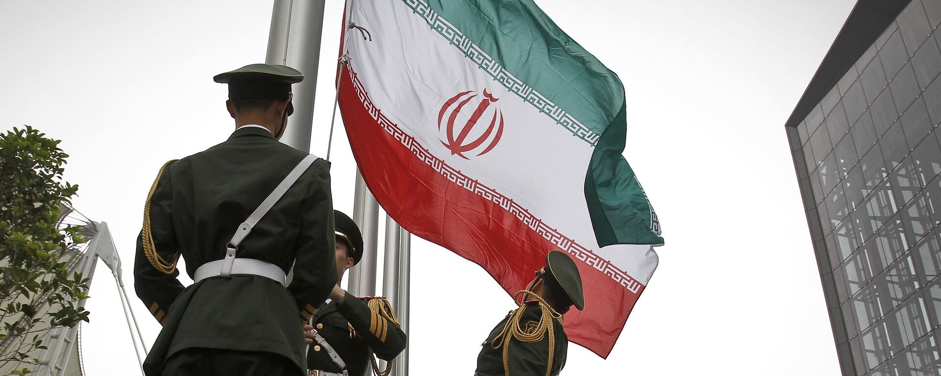 Policiais paramilitares chineses hasteiam uma bandeira nacional iraniana em uma cerimônia de hasteamento da bandeira durante a visita do presidente iraniano Mahmoud Ahmadinejad à Expo Mundial de Xangai em Xangai, China (foto de arquivo) - Sputnik Brasil, 1920, 16.04.2024