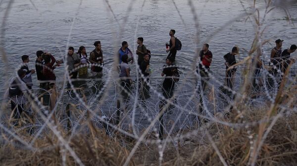 Migrantes esperam para escalar a margem após cruzarem o Rio Grande em direção aos EUA vindos do México, em Eagle Pass, Texas. EUA, 23 de setembro de 2023 - Sputnik Brasil