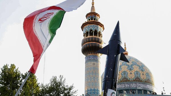 Os iranianos levantam uma bandeira e a maquete de um míssil durante uma celebração após o ataque de mísseis e drones do Irã a Israel, em 15 de abril de 2024 - Sputnik Brasil