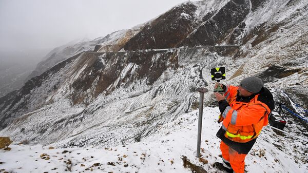 Um trabalhador instala um equipamento de topografia enquanto a neve cai na área de Pretty Rocks Landslide, no Denali National Park, Alasca - Sputnik Brasil