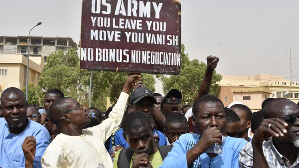 Manifestantes com cartaz exigindo que os soldados do Exército dos EUA deixem o Níger sem negociação durante manifestação em Niamey, Níger, 13 de abril de 2024 - Sputnik Brasil