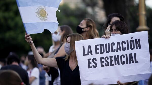 Mulher segura cartaz em que se lê A educação é essencial durante protesto em frente ao Ministério da Educação argentino, em Buenos Aires, em 16 de abril de 2021 - Sputnik Brasil