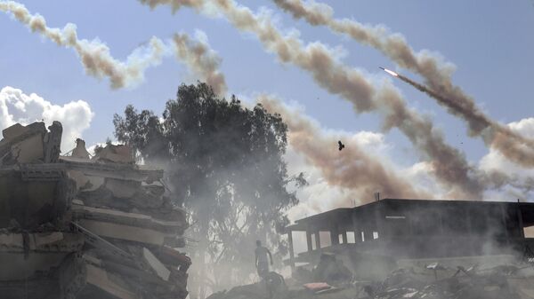 Foguetes são disparados da Faixa de Gaza em direção a Israel em meio a edifícios destruídos, após ataques aéreos israelenses na Cidade de Gaza. Faixa de Gaza, 19 de outubro de 2023 - Sputnik Brasil