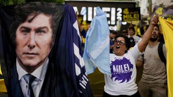 Apoiadora de Javier Milei com bandeiras da Argentina e do presidente eleito, em 15 de novembro de 2023 - Sputnik Brasil