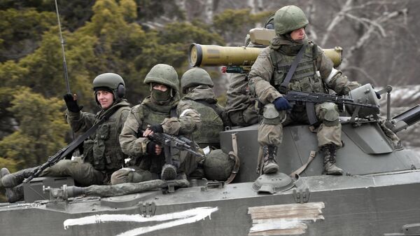 Militares russos dirigem um veículo militar durante a operação militar especial da Rússia na Ucrânia - Sputnik Brasil