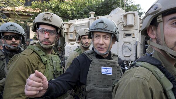 O primeiro-ministro israelense, Benjamin Netanyahu, ao centro, usa colete protetor e capacete ao receber instruções de segurança com comandantes e soldados no norte da Faixa de Gaza, 25 de dezembro de 2023 - Sputnik Brasil