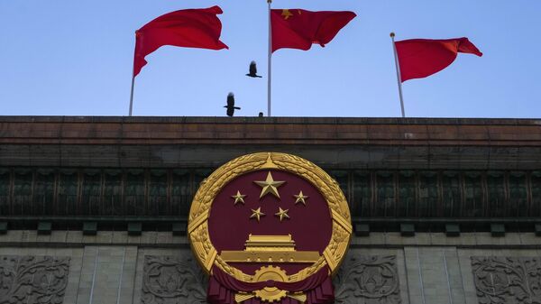 Pássaros passando voando pelas bandeiras chinesas que tremulam sobre o emblema nacional chinês fora do Grande Salão do Povo em Pequim, 3 de março de 2023 - Sputnik Brasil