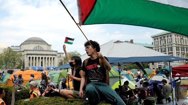 Estudantes manifestantes na Universidade de Columbia agitam bandeiras palestinas no gramado em 29 de abril de 2024 - Sputnik Brasil