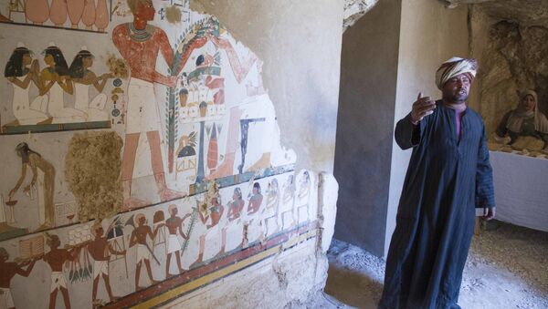 Um guarda egípcio ao lado de um mural fúnebre dentro de um túmulo recentemente descoberto, conhecido como KAMPP 161 durante um anúncio do Ministério das Antiguidades egípcio sobre novas descobertas em Luxor, no Egito. - Sputnik Brasil