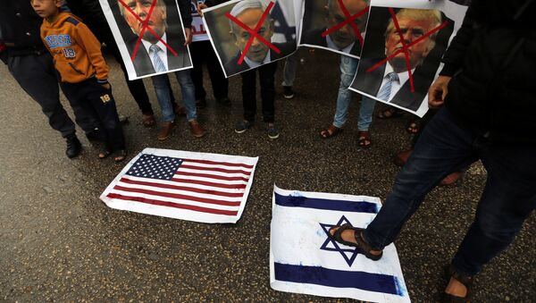 A Palestinian man steps on a representation of an Israeli flag as other demonstrators hold crossed out posters of US President Donald Trump and Israeli Prime Minister Benjamin Netanyahu during a protest against the U.S. intention to move its embassy to Jerusalem and to recognize the city of Jerusalem as the capital of Israel, in Rafah in the southern Gaza Strip December 6, 2017. - Sputnik Brasil