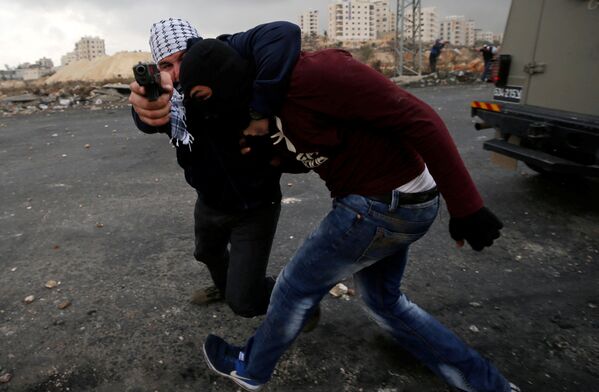 Um agente da inteligência israelense à paisana detém um manifestante palestino durante os protestos perto do povoado judeu de Beit El, a pouca distância da cidade de Ramallah, na Cisjordânia, em 13 de dezembro de 2017 - Sputnik Brasil
