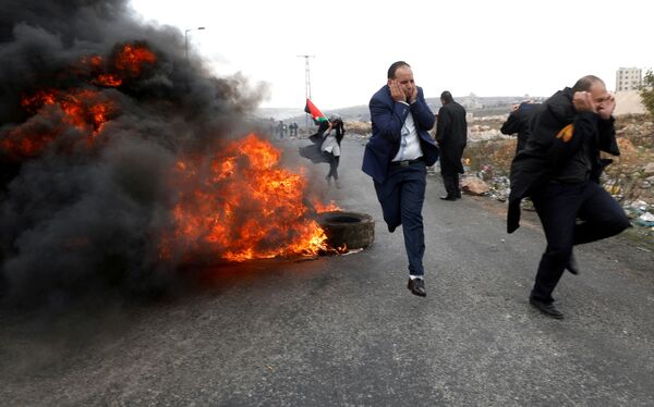 Advogados palestinos fogem durante confrontos com as tropas israelenses durante os protestos contra a decisão de Donald Trump de reconhecer Jerusalém como capital do Estado judeu, em 13 de dezembro de 2017 - Sputnik Brasil