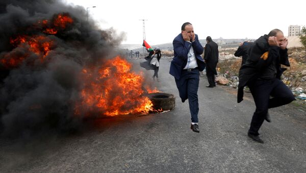 Advogados palestinos fogem durante confrontos com as tropas israelenses durante os protestos contra a decisão de Donald Trump de reconhecer Jerusalém como capital do Estado judeu, em 13 de dezembro de 2017 - Sputnik Brasil