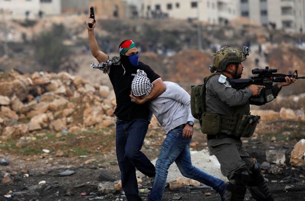 Agentes dos serviços secretos israelenses que trabalham à paisana detêm um manifestante palestino perto do povoado de Beit El, a pouca distância da cidade de Ramallah, na Cisjordânia, em 13 de dezembro de 2017 - Sputnik Brasil