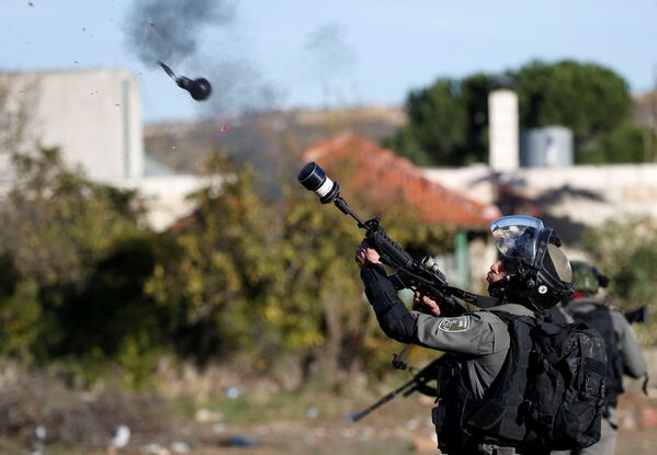 Um guarda fronteiriço israelense lança gás lacrimogêneo contra os manifestantes palestinos durante os confrontos provocados pela decisão de Donald Trump de reconhecer Jerusalém como capital do Estado judeu, em 9 de dezembro de 2017 - Sputnik Brasil