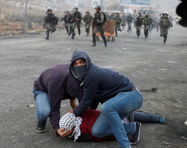 Um agente da inteligência israelense à paisana detém um manifestante palestino durante os protestos perto do povoado judeu de Beit El, a pouca distância da cidade de Ramallah, na Cisjordânia, em 13 de dezembro de 2017 - Sputnik Brasil