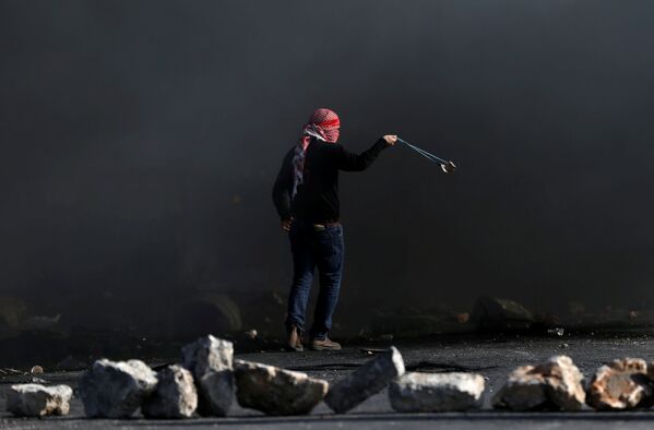 Um manifestante palestino usa bodoque para lançar pedras contra os soldados israelenses durante os confrontos perto do povoado de Beit El, a pouca distância da cidade de Ramallah, na Cisjordânia, em 11 de dezembro de 2017 - Sputnik Brasil