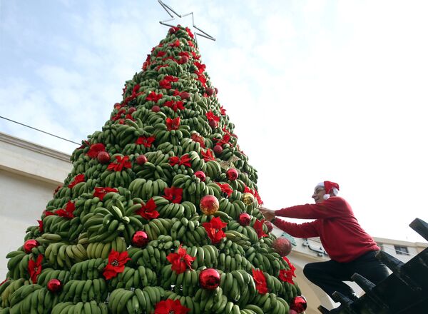 Homem adorna árvore de Natal feita de bananas na região de Damour, ao sul de Beirute, Líbano, em 19 de dezembro de 2017 - Sputnik Brasil