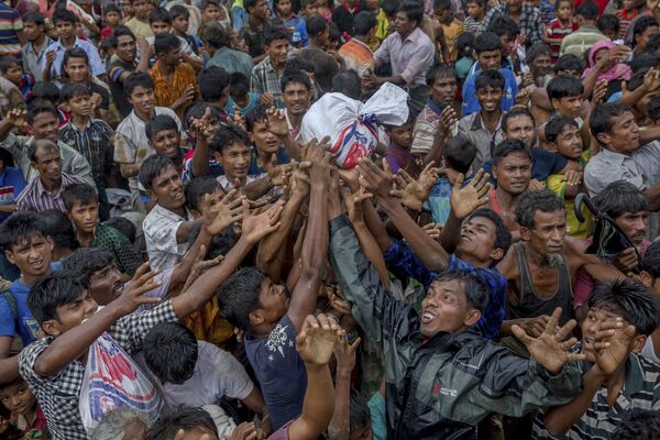 Segundo a organização Médicos Sem Fronteiras (MSF), ao menos 6.700 pessoas foram mortas pelo exército de Mianmar - que persegue os muçulmanos de etnia Rohingya no país. A violência causou o deslocamento forçado de milhares deles para os países vizinhos. Na foto, membros de um campo de refugiados em Bangladesh disputam alimentos. - Sputnik Brasil