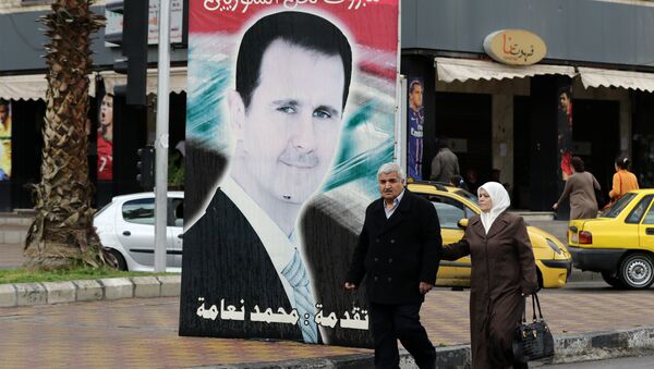 Sírios passeando perto do retrato do presidente do país, Bashar Assad - Sputnik Brasil