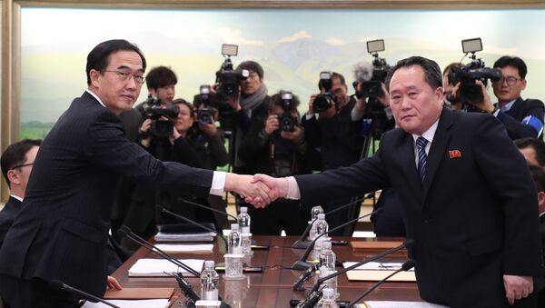 Ministro da Unificação da Coreia do Sul, Cho Myung-gyun (à esquerda), e líder da delegação norte-coreana Ri Son-gwon apertando as mãos durante negociações bilaterais na zona desmilitarizada, 9 de janeiro de 2017 - Sputnik Brasil