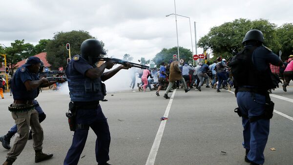 South African riot policemen fire rubber bullets to disperse Somali and foreign nationals clashing with South African nationals during a protest march against illegal immigrants on February 24, 2017 in Pretoria, South Africa. - Sputnik Brasil