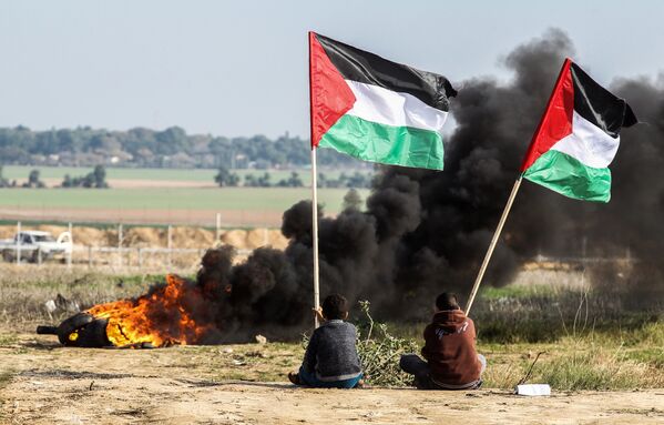Palestinos agitam bandeiras nacionais na fronteira entre Israel e Faixa de Gaza - Sputnik Brasil