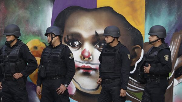 In this Monday, Jan. 9, 2017 photo, police providing security walk past street art as thousands march against the government of Enrique Pena Nieto following a 20 percent rise in gas prices in Mexico City. - Sputnik Brasil